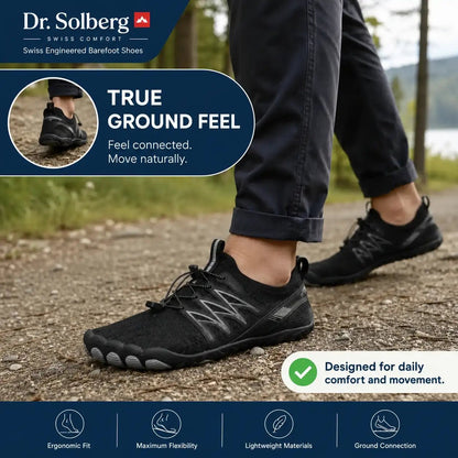 Black unisex barefoot shoe with textured rubber sole and lace-up upper, side view
